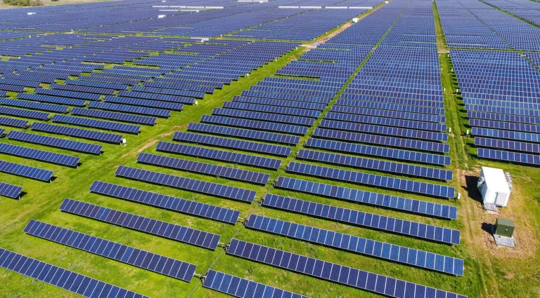 Large-scale solar panel installation covering farmland in Jefferson County New York with rows of photovoltaic panels across open land