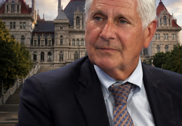 Bruce Blakeman in a suit posed before the New York State Capitol in Albany with WatertownPost.com branding at the bottom.