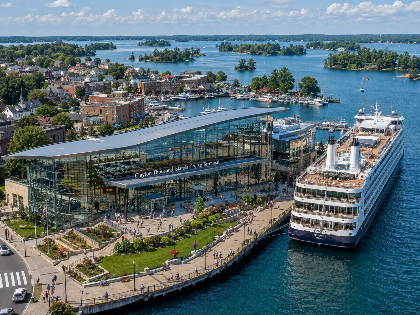 Concept image of a modern cruise terminal in Clayton, New York, featuring a large glass-fronted waterfront building, landscaped public promenade, docked cruise ship, marina, and Thousand Islands scenery in the background.
