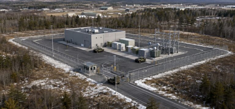 Conceptual aerial view of a compact nuclear microreactor facility enclosed by security fencing at Fort Drum in Northern New York.
