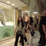 Four people walking together outdoors in Iran, smiling and enjoying daily life in a modern urban setting.