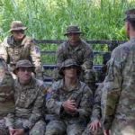Seated 10th Mountain Division soldiers listen to Maj. Gen. Scott Naumann before a jungle-course graduation in Panama.
