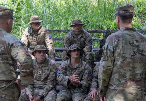 Seated 10th Mountain Division soldiers listen to Maj. Gen. Scott Naumann before a jungle-course graduation in Panama.